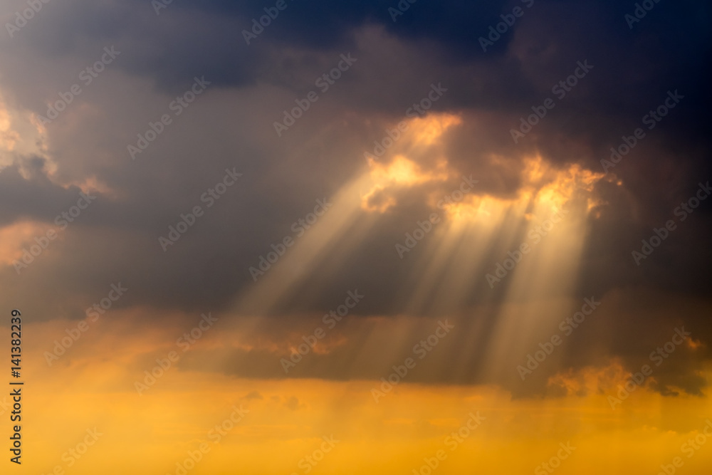 Wall mural a ray of sunlight breaking through dark clouds.