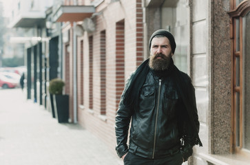 Fototapeta na wymiar bearded man hipster with serious face in leather jacket