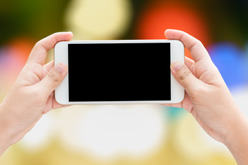 Woman hands using smart phone on bokeh background.