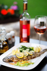 Grilled fish and green salad on the table