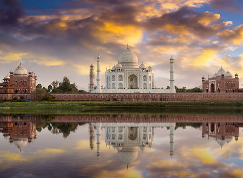 Taj Mahal at sunset as seen from the Yamuna river banks with moody sky. Taj Mahal designated as a World Heritage Site is a masterpiece of Indian heritage and architecture.
