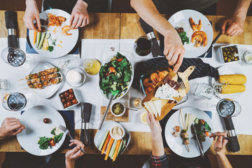 Top view of food table, happiness and togetherness concept, group of hipsters dinning eating...