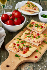 Italian pizza with salami, peppers and tomatoes on wooden table background