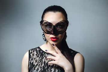 Beautiful Woman with Black Lace mask over her Eyes. Red Sexy Lips and Nails closeup. Open Mouth....