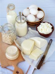 Set of fresh dairy products on wooden background: milk, cheese, cottage, yogurt, egg, mozzarella, ryazhenka, feta.