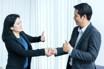 Asian woman and man handshake and showing thumbs up.