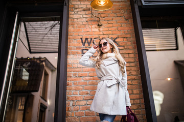Obraz premium Beautiful young woman walking on the street near work place building