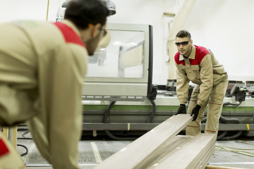 Obraz premium Young men working in furniture factory