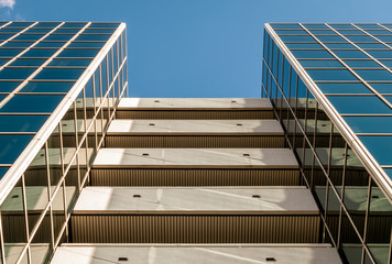 Fototapeta premium Urban Geometry, looking up to glass building. Modern architecture, glass and steel. . Abstract architectural design. Inspirational, artistic image.Minimal art. Architectural design. Building exterior.