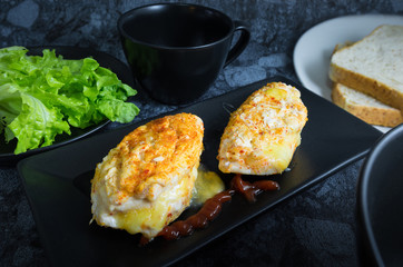 Chicken breast spicy with cheese, bread, vegetable (green oak) tomato sauce and coffee in dark background.