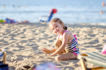 Girl playing on the beach with sand