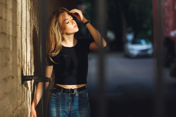 Fototapeta premium Street style. Beautiful woman walks on the street at the Moscow City at sunny spring day.