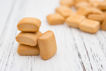 square shape biscuit stacks up on white wood