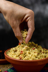 young man eating tabbouleh with his hand