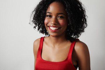 black woman in red dress with bright red lips and curly hair