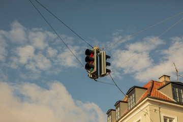 Red and green traffic lights against blue sky background
