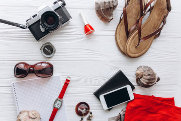 Top view of female  travel accessories set on blue  wooden background with copy space