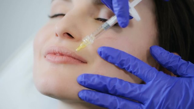 Woman receives cosmetic injection in lips
