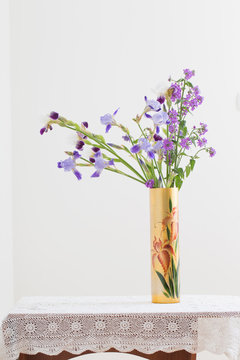 bouquet of spring purple Iris in a vase on white