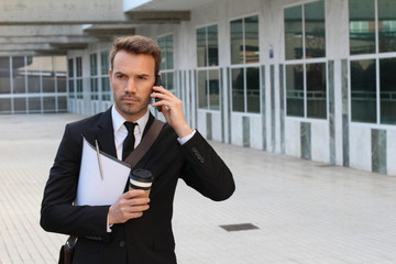 Focused businessman walking during phone call outdoors