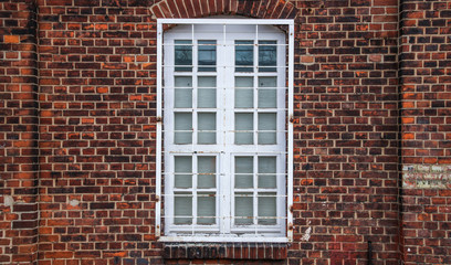 Vergittertes Fenster eines Backsteinhauses