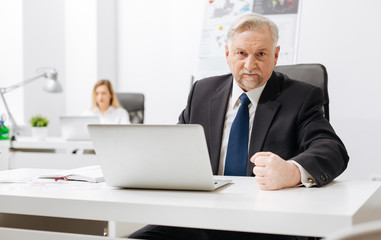 Impatient aged employer expressing fury in the office