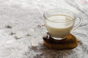 Milk with ice cubes on a wooden stand in the kitchen