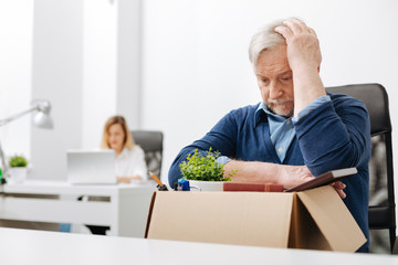 Upset office worker gathering belongings into the box