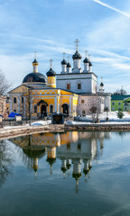 Fototapeta na wymiar vintage Voznesenskaya Davidova Pustyn monastery Chekhov district, Russia, historical and cultural monuments of the vertical frame with reflection in water