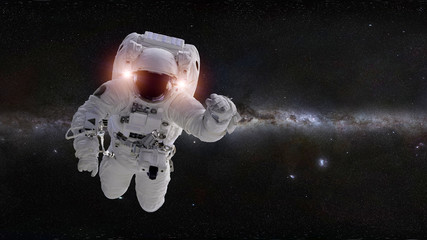 astronaut in front of the Milky Way galaxy (elements of this image are furnished by NASA) © dottedyeti