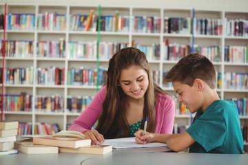 Fototapeta premium School kids doing homework in library at school