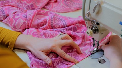 Professional tailor, fashion designer sewing clothes with sewing machine at atelier. Fashion and tailoring concept