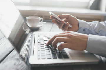 Hands using laptop and phone for online shopping, Daytime soft light