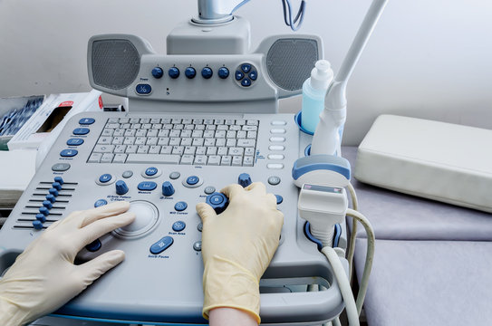 The doctor's hands on the ultrasound machine