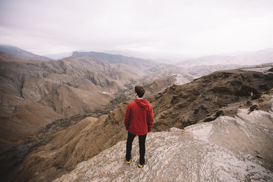 Male standing in mountains looking into distance