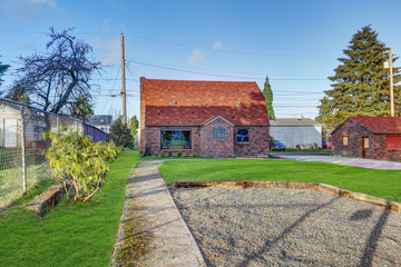 Small red brick home on a sunny day