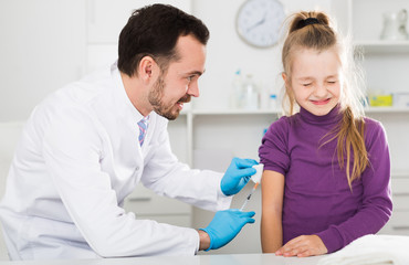 Obraz premium Male doctor injecting little patient