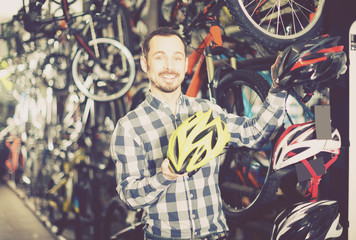 Fototapeta na wymiar Man offers a choice of helmets for cyclists