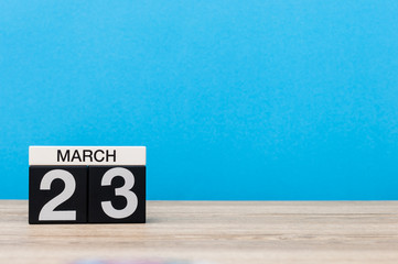 March 23rd. Day 23 of month, calendar on table with blue background. Spring time, empty space for text