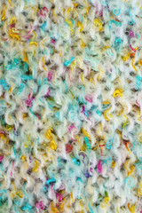 Colorful light hand made crochet or knitting textile fabric texture. Close up macro background.