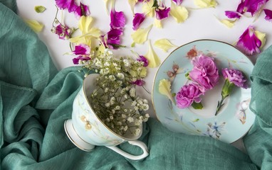 Creative composition with cup and natural flowers.