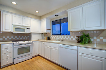 White kitchen design with hardwood floor and white appliances