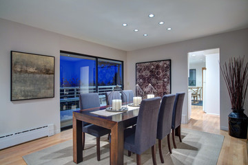 Grey tones dining space with glass doors to large upper deck