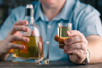 man offers whiskey. Elegant man keeps and holds a glass