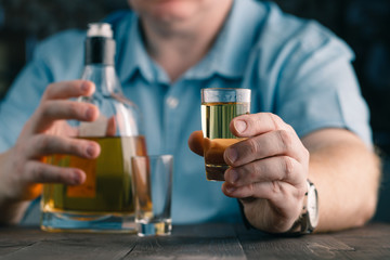 man offers whiskey. Elegant man keeps and holds a glass