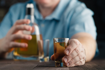 Fototapeta na wymiar man offers whiskey. Elegant man keeps and holds a glass