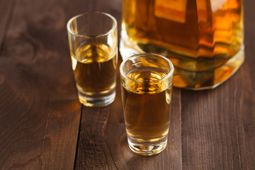 gold tequila in a glass on a background of bright lights. Traditional Mexican drink.