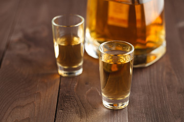 gold tequila in a glass on a background of bright lights. Traditional Mexican drink.
