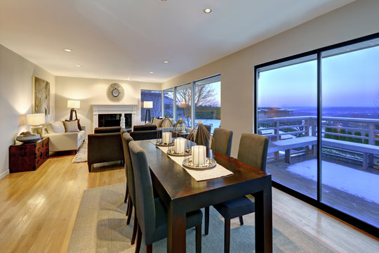 Grey tones dining space with glass doors to large upper deck