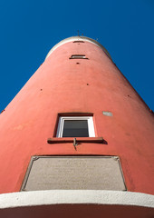 Perspective view on the old lighthouse near De Cocksdorp against crisp blue sky.